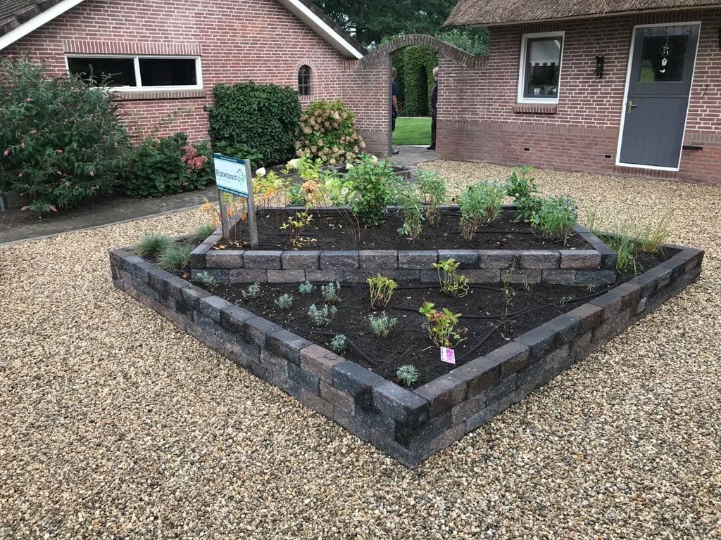 Nieuw beplante verhoogde borders met een bord van Bijsterbosch Hoveniersbedrijf