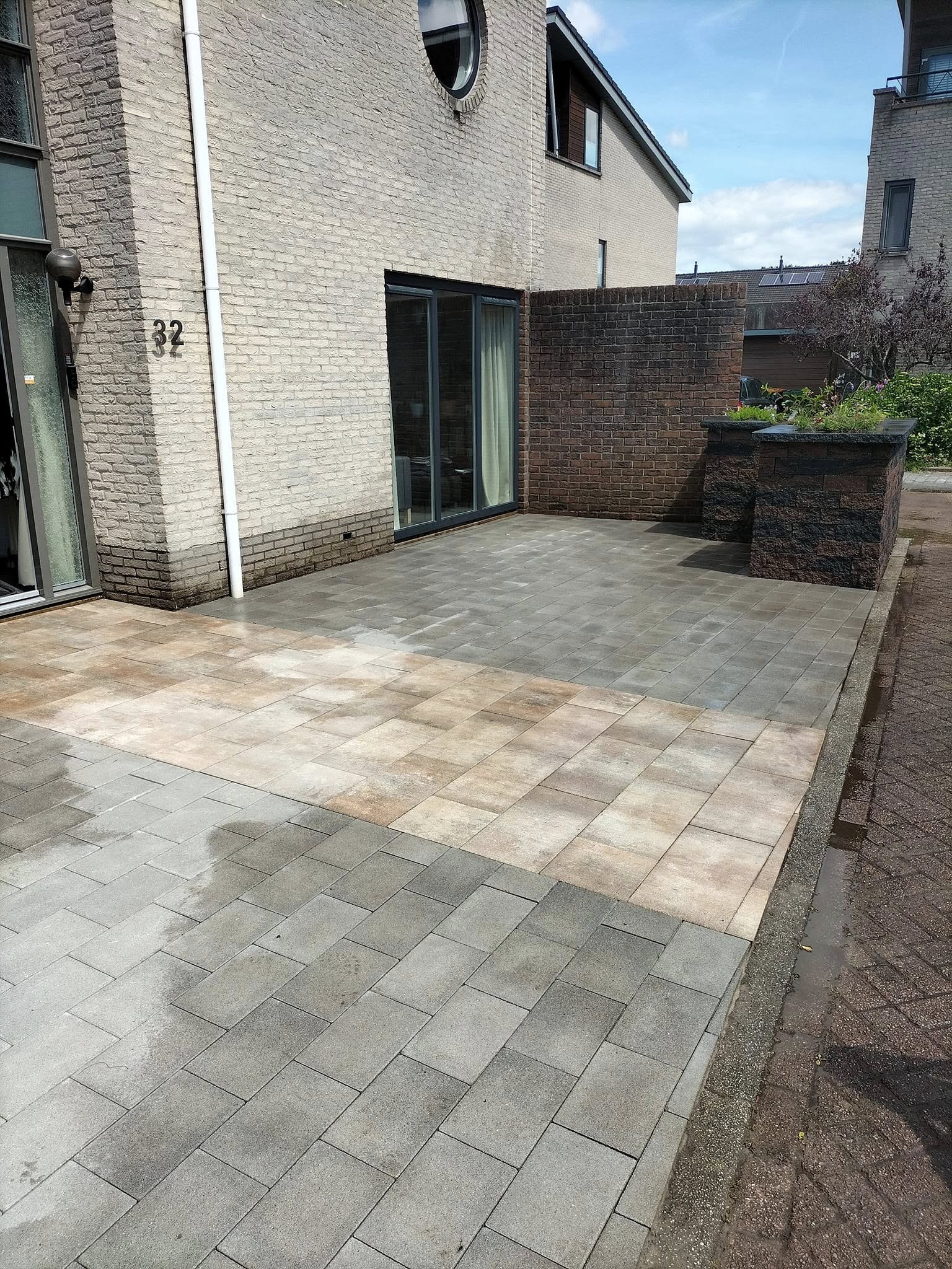 Nieuw gelegd terras met grote tegels bij een woning