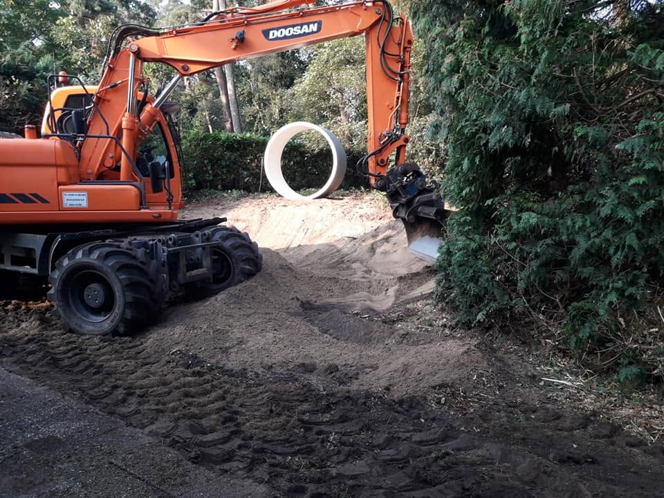 Graafmachine aan het werk bij het grondwerk voor een nieuwe tuin