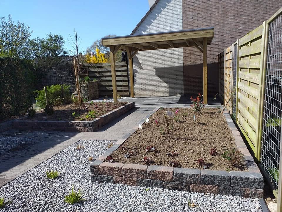 Nieuw aangelegde tuin met houten overkapping, schutting en borders